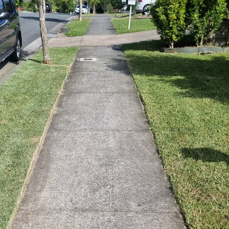 Mown grass edges beside a footpath and trimmed hedge