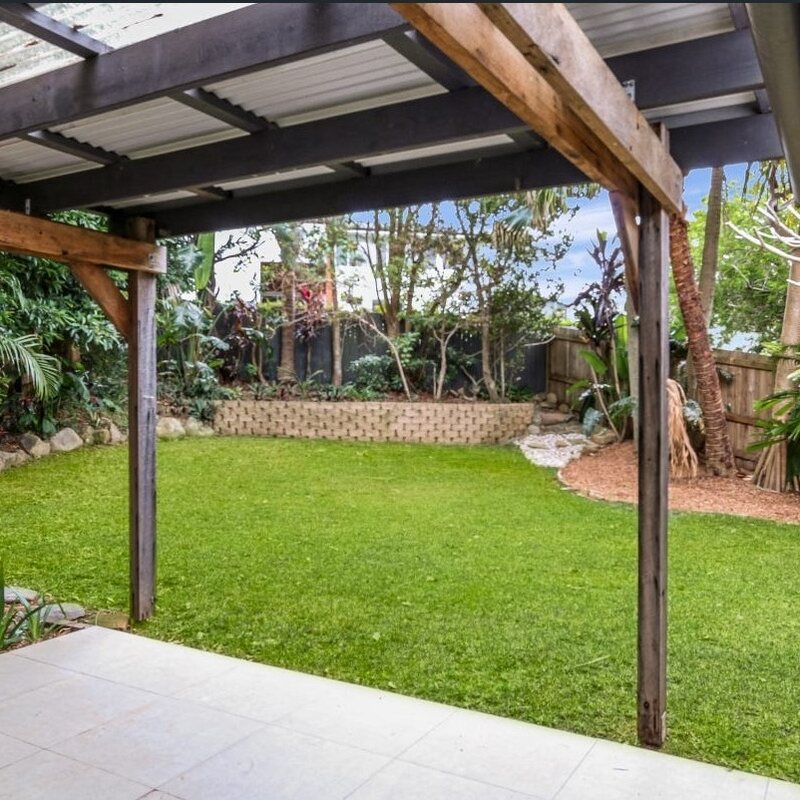 Green backyard lawn beneath a timber patio